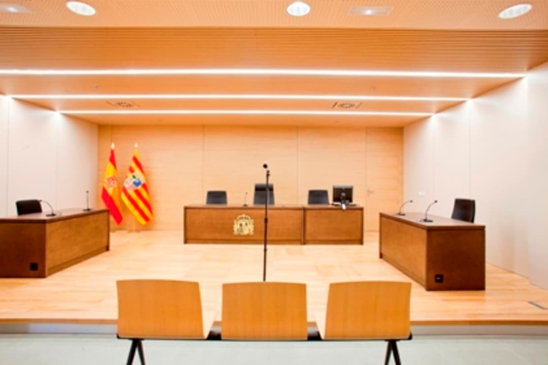 Sala de vistas de un juzgado vacía, simbolizando la transición a juicios telemáticos.
